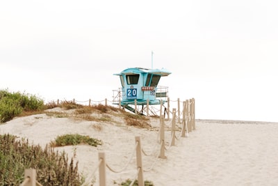 The blue wooden lifeguards on the beach during the day
